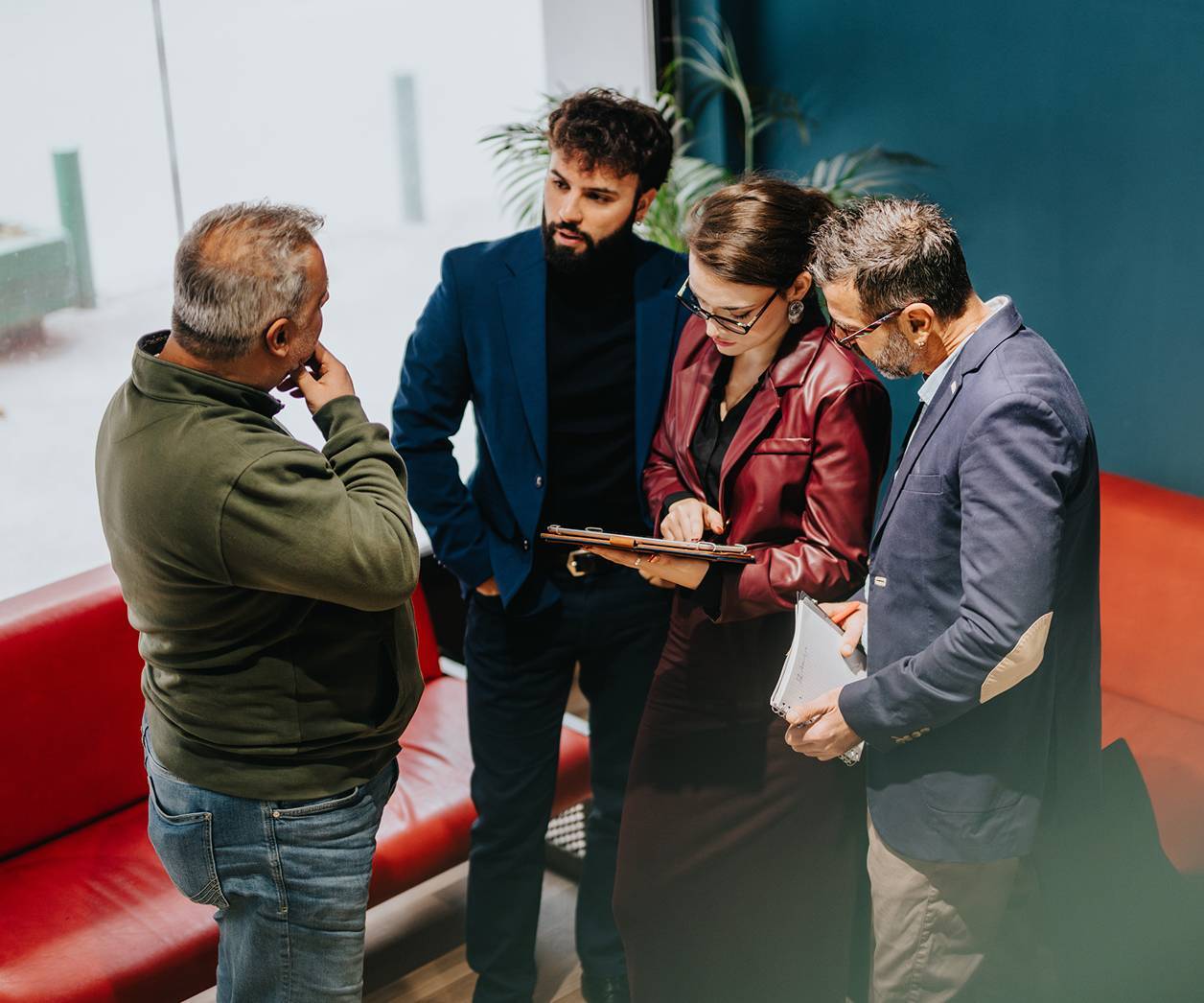 Four business collegues in coversation looking at documents