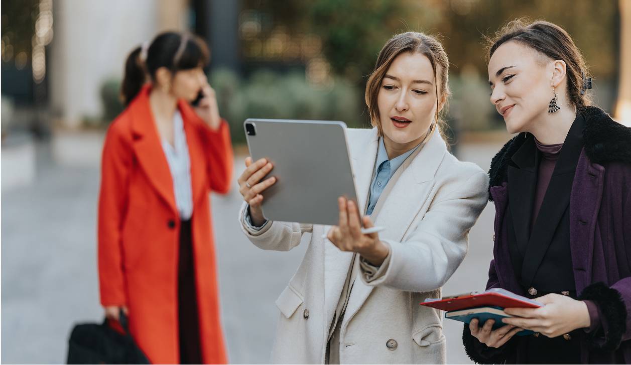 Two businesswomen viewing a tablet outside-rectangle