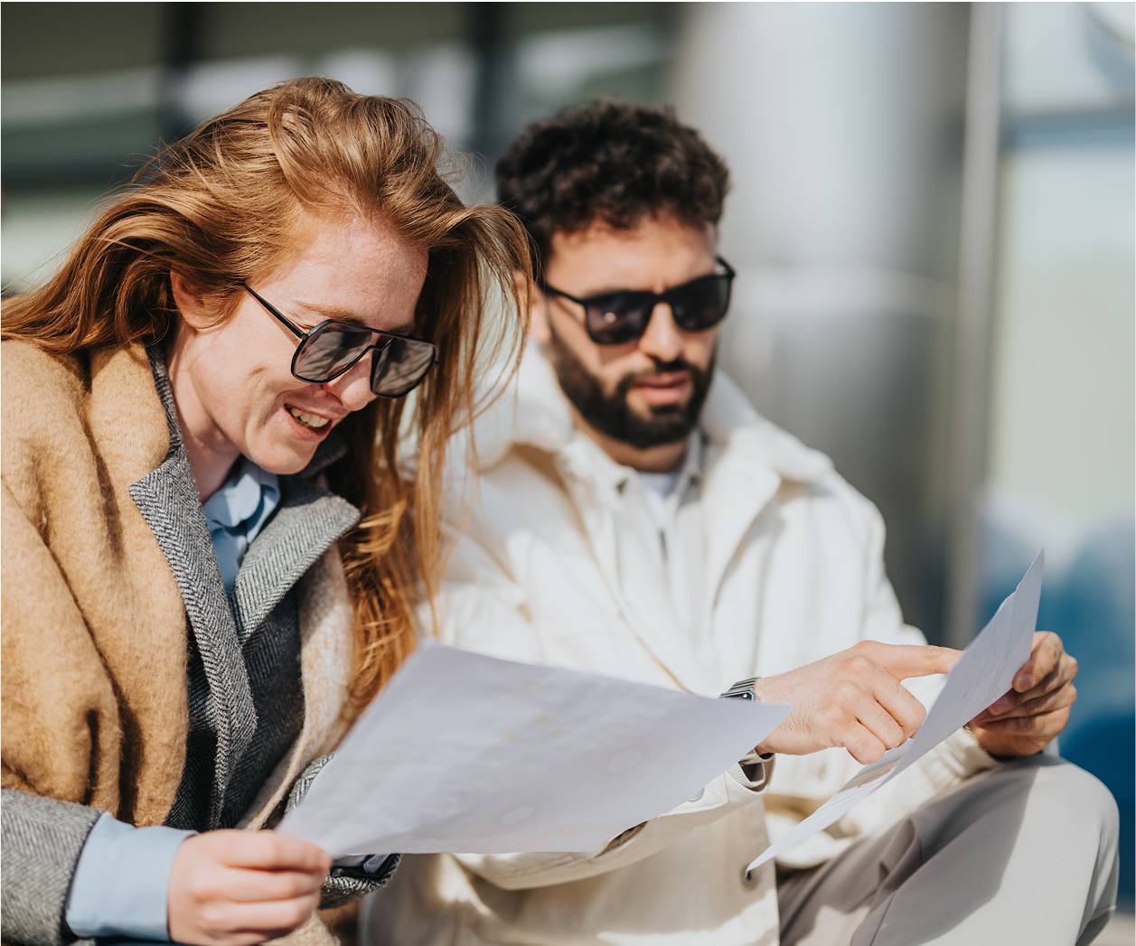 Two people sat outside looking at papers