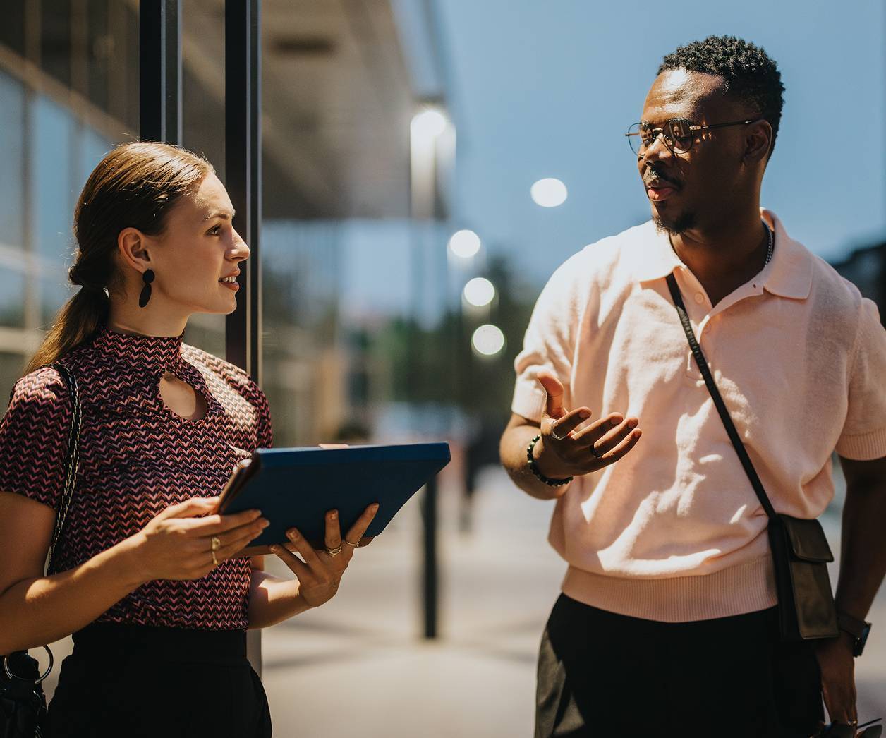 Two young professionals talking in evening