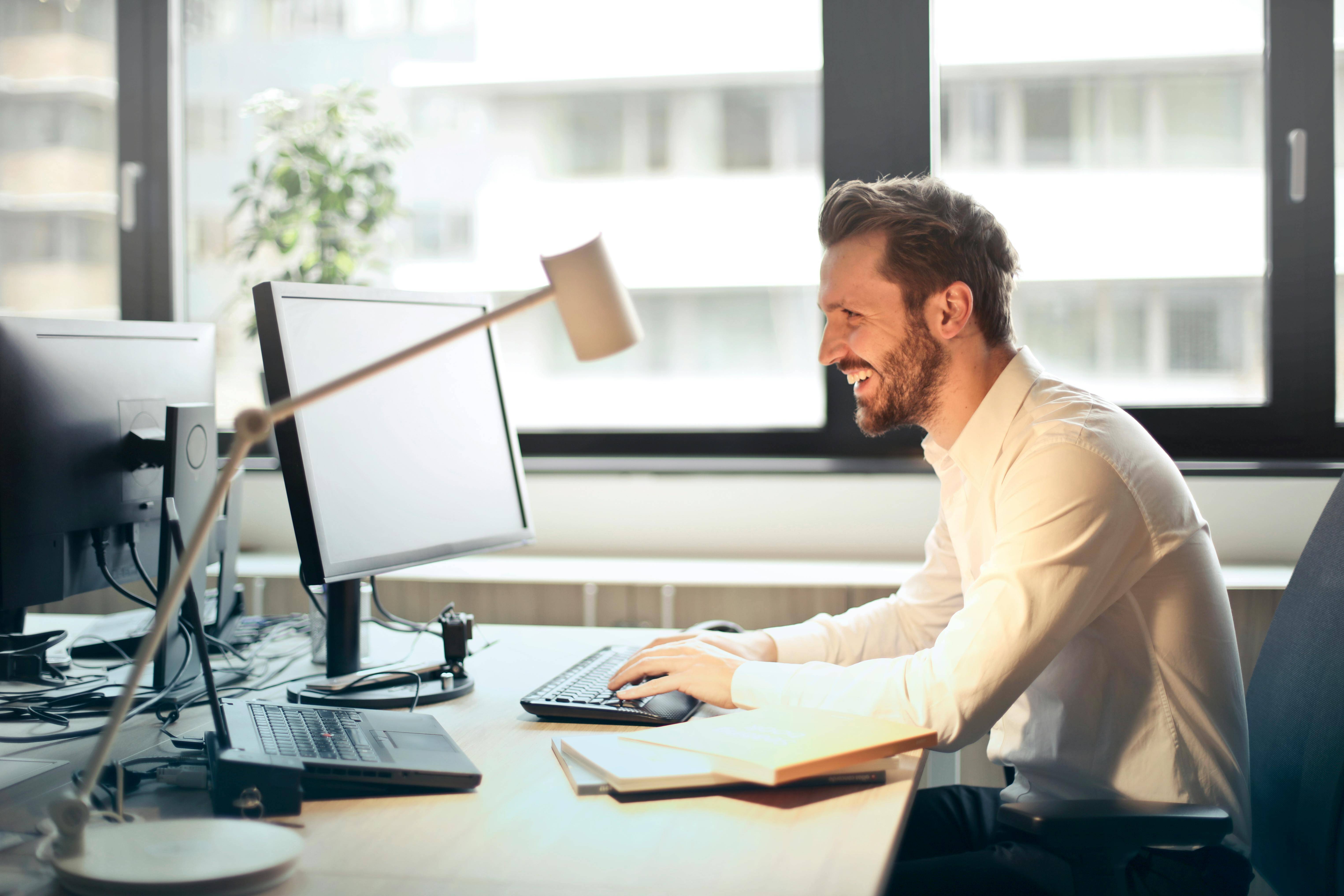 Smiling man typing on a keyboard