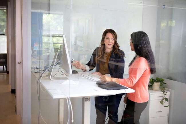 Women standing by a computer screen 